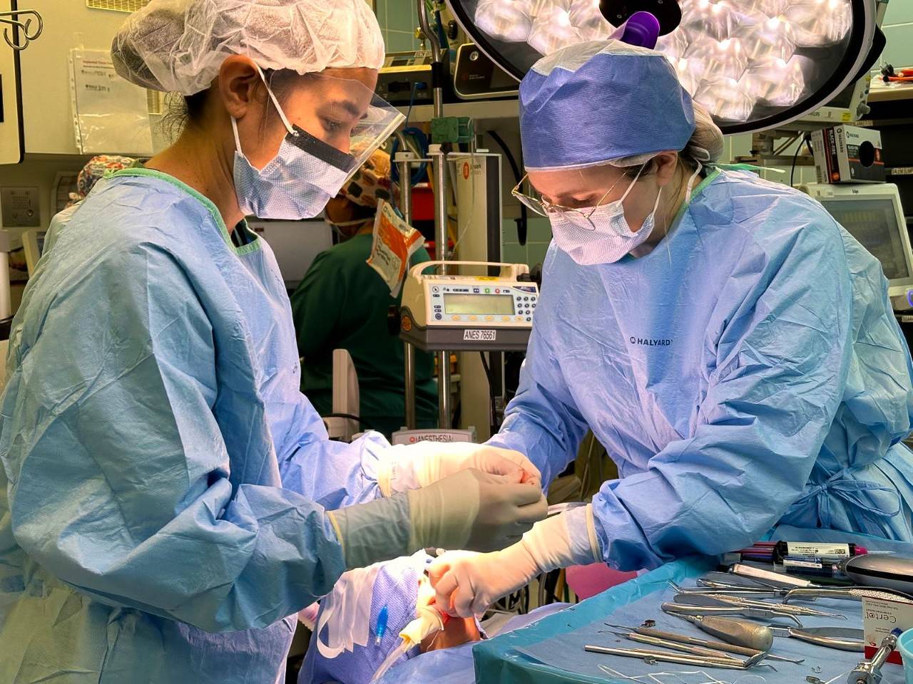 A participant of a Red Cross Dental Assistant Program assists her instructor during a routine tooth cleaning.